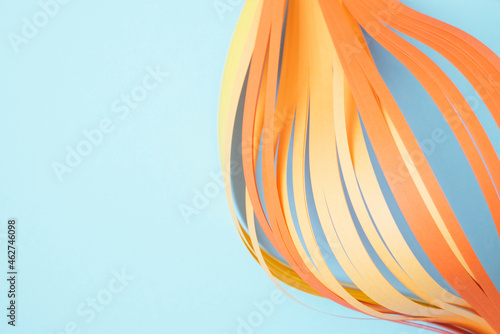 Close-up of orange quilling papers on blue background photo