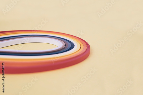 Close-up of multi colored quilling papers on beige background photo
