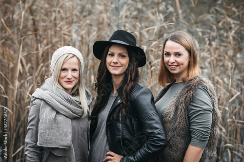 Portrait of three smiling friends in autumnal nature photo