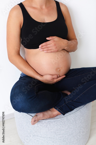 Young pregnant woman sitting on chair photo