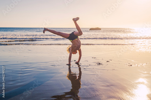 Little boy practicing handstand on the beach photo