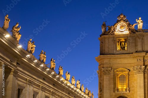 Illuminated saint statues on St. Peter's Basilica against clear blue sky at night, Vatican City, Rome, Italy photo