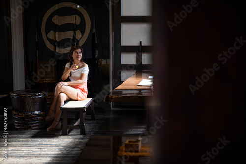 Japan, Takayama, Portrait of young woman drinking sake in traditional Japanese winery