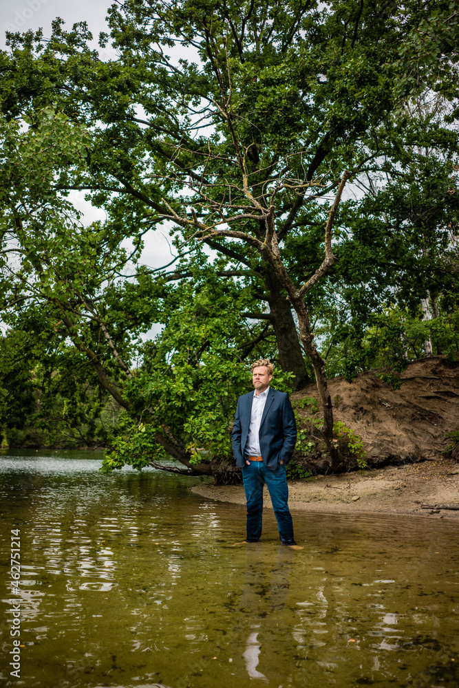 Businessman at a lonely island in a lake Businessman at a lonely island in a lake