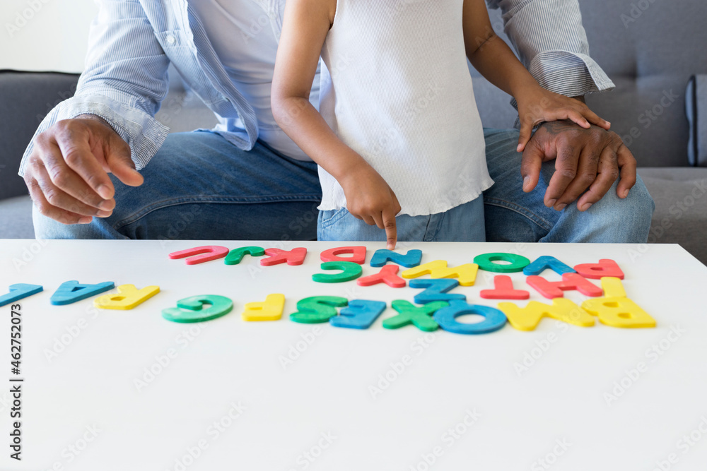 Close-up of father and daughter playing with alphabet learning game at home Close-up of father and daughter playing with alphabet learning game at home