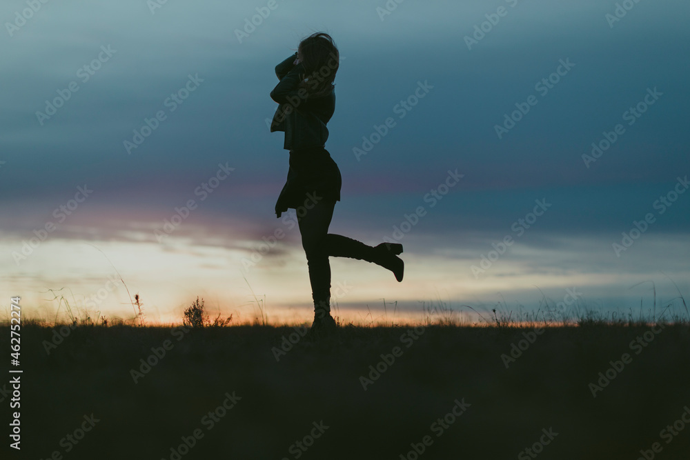 Silhouette of woman in nature at sunset Stock Photo | Adobe Stock