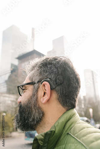 Man with cochlear implant in front of skycrapers, Frankfurt, Germany photo