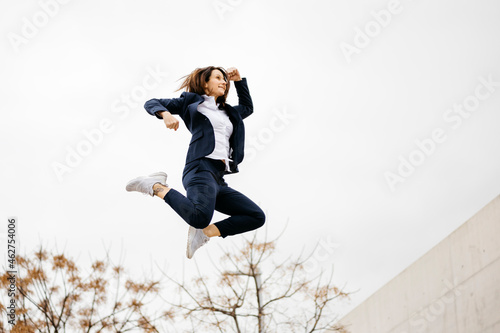 Happy businesswoman jumping in the city photo