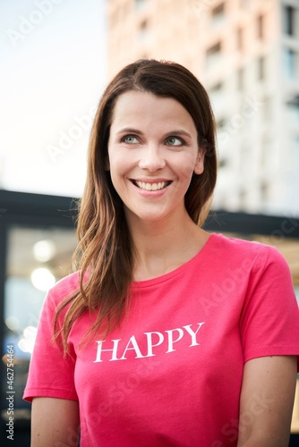 Portrait of happy woman wearing pink t-shirt in the city photo