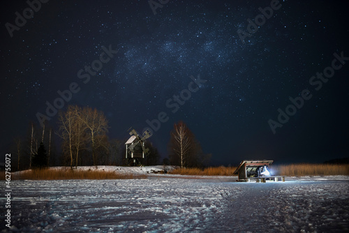 Finland, Kuopio, woman at campfire in winterat night photo