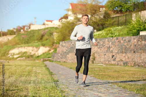 Sporty young man jogging in...