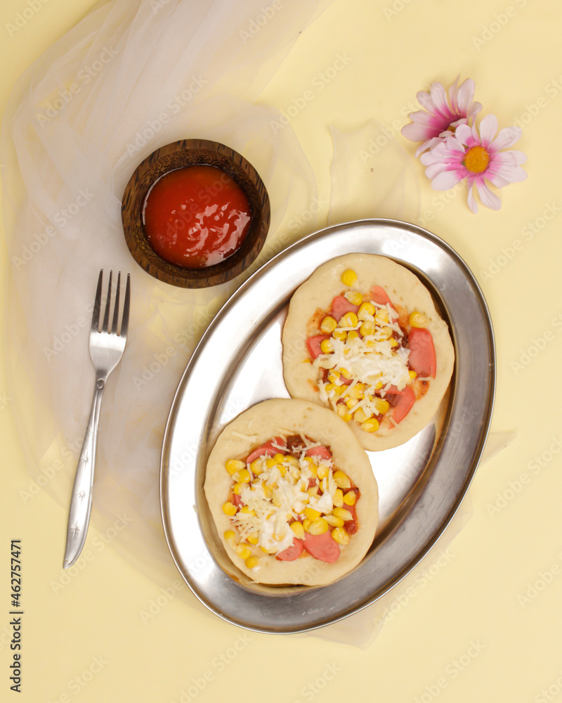 Mini pizza with corn, sausage and cheese topping for your lunch menu. pizza is a savory dish from Italy a kind of round and flat dough, baked in the oven. Pizza mockups. Focus blur. Focus on some ange Mini pizza with corn, sausage and cheese topping for your lunch menu. pizza is a savory dish from Italy a kind of round and flat dough, baked in the oven. Pizza mockups. Focus blur. Focus on some ange