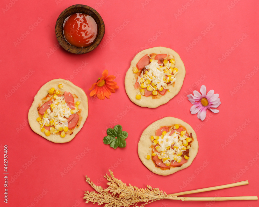 Mini pizza with corn, sausage and cheese topping for your lunch menu. pizza is a savory dish from Italy a kind of round and flat dough, baked in the oven. Pizza mockups. Focus blur. Focus on some ange Mini pizza with corn, sausage and cheese topping for your lunch menu. pizza is a savory dish from Italy a kind of round and flat dough, baked in the oven. Pizza mockups. Focus blur. Focus on some ange