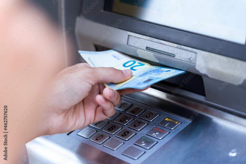 Close up of businesswoman withdraw money on a cash machine Close up of businesswoman withdraw money on a cash machine
