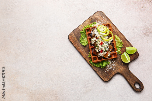Tasty Belgian waffle with vegetables and lime on light background