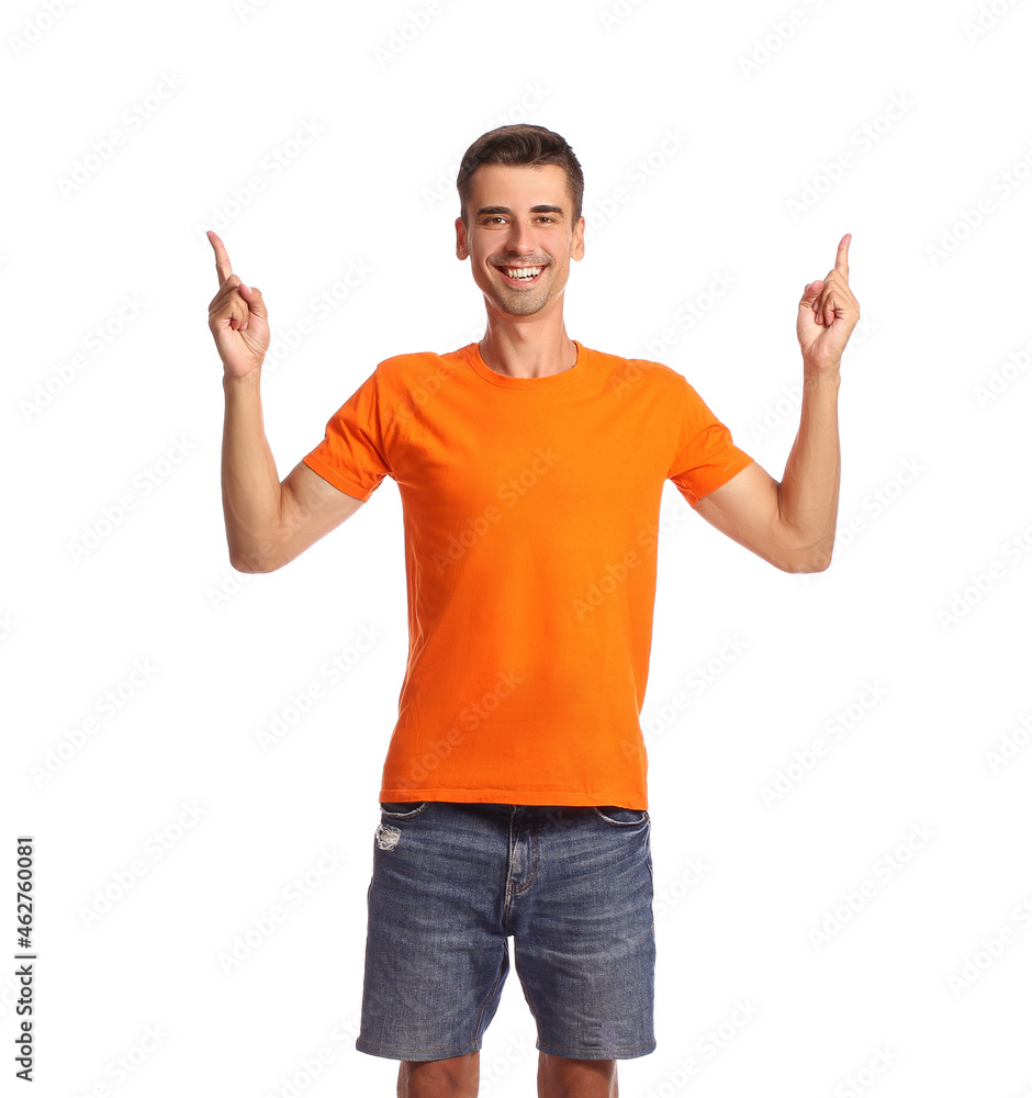 Handsome young man in stylish t-shirt pointing at something on white background Handsome young man in stylish t-shirt pointing at something on white background