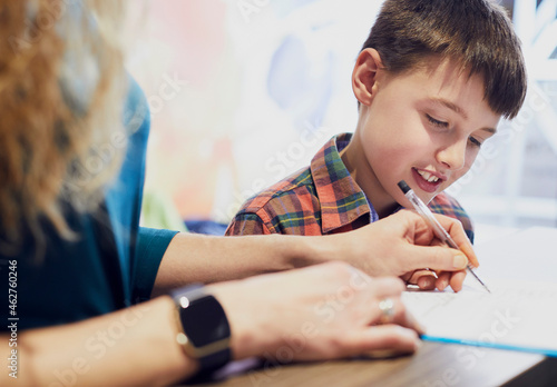 Mother filling in form for her son at medical practice photo