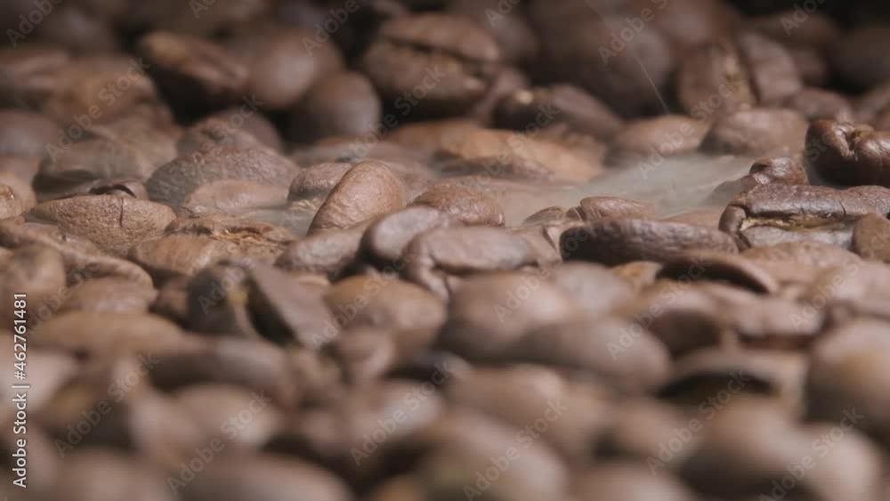 Close up slow motion shot of roasting coffee beans as smoke starts to appear bringing out the beautiful aroma and flavours Close up slow motion shot of roasting coffee beans as smoke starts to appear bringing out the beautiful aroma and flavours