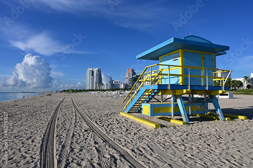 Colorful lifeguard station on Miami Beach, Florida under late summer cloudscape in early morning light with residential towers in background. © Francisco