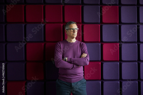 Businessman standing at a noise reduction wall in office photo