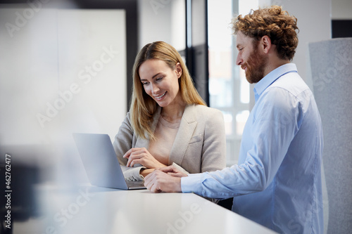 Businessman and businesswoman working together with laptop in office