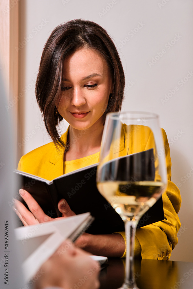 Young women with short hair reading restaurant menu Young women with short hair reading restaurant menu