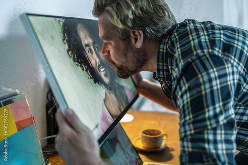 Man kissing man on computer screen