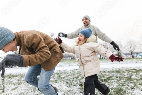 Father and two children having a snowball fight photo