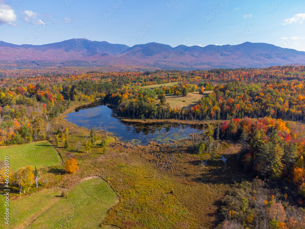 aerial view of autumn forest, pond and mountain