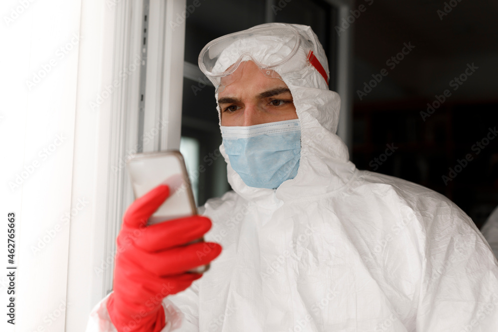 Man in protective clothing, using smartphone Man in protective clothing, using smartphone