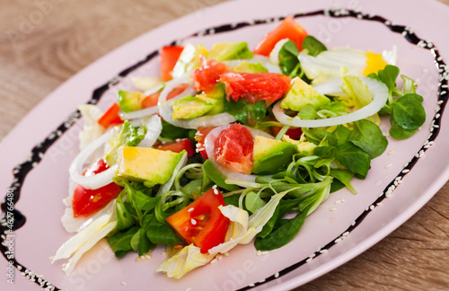 Vitamin salad from avocado, tomatoes, grapefruit and fresh cornsalad in white plate..