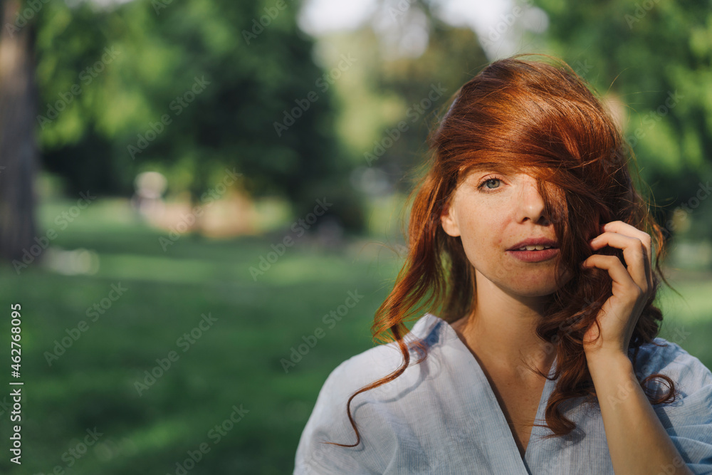 Portrait of a beautiful redheaded woman in a park Portrait of a beautiful redheaded woman in a park
