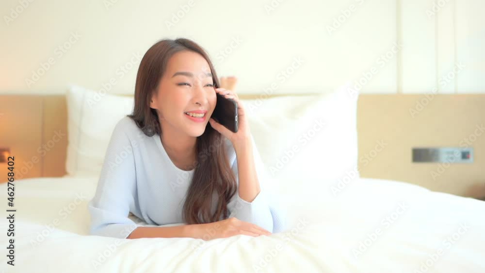 Beautiful Asian Woman Talking on Mobile Phone in Bedroom, Full Frame, Slow Motion Beautiful Asian Woman Talking on Mobile Phone in Bedroom, Full Frame, Slow Motion