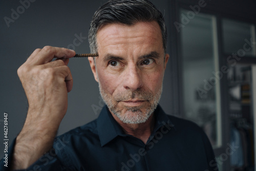 Portrait of mature businessman holding a rusty screw photo