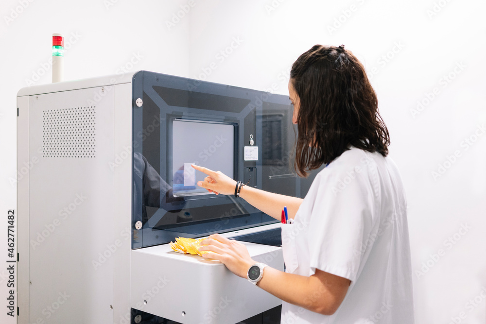 Female doctor using computer over machinery in pharmacy at hospital Female doctor using computer over machinery in pharmacy at hospital