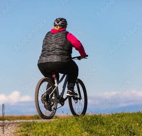 Bilde på lerret Overweight woman slimming on bicycle outdoor in the park