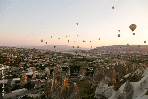 Hot air balloons flying over landscape against clear sky at Goreme National Park, Cappadocia, Turkey photo