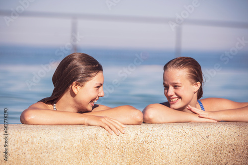 Friends looking at each other in swimming pool photo