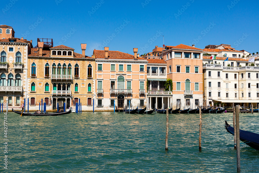Picturesque Venice cityscape with Grand canal, moored boats, gondolas and ancients colorful buildings on banks of canal