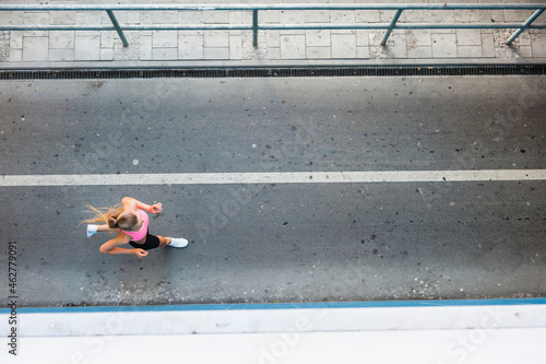 Female jogger on street in the city, from above photo