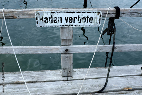 Germany, Schleswig Holstein, Wendtorf, Jetty on Baltic Sea with sign saying bathing prohibited photo