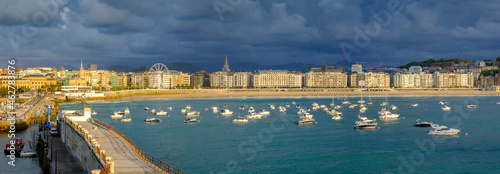 Spain, Gipuzkoa, San Sebastian, Panorama of storm clouds over various boats floating in Bay of LaÔøΩConcha