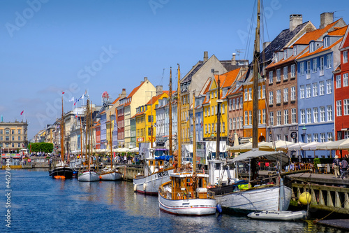 Denmark, Copenhagen, Boats moored along Nyhavn canal with colorful townhouses in background photo
