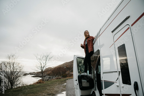 UK, Scotland, Highland, happy young woman at a camper van photo