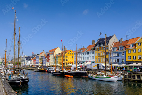 Denmark, Copenhagen, Boats moored along Nyhavn canal with colorful townhouses in background photo