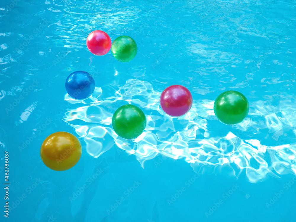 Pool fun concept with an inflatable plastic beach ball floating in
