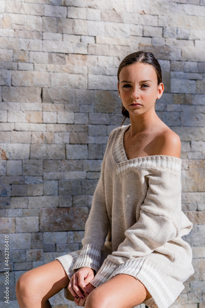 © Javier De La Torre Sebastian/Westend61 - Stylish teenage girl wearing off shoulder dress posing while sitting against brick wall © Javier De La Torre Sebastian/Westend61 - Stylish teenage girl wearing off shoulder dress posing while sitting against brick wall