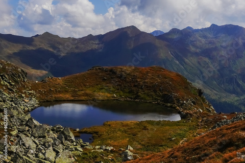 Fototapeta Naklejka Na Ścianę i Meble -  deep blue mountain lake with reflections in colorful mountains
