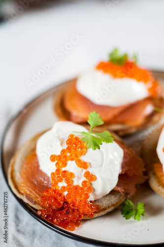 Blinis with sour cream, smoked salmon and fish roe photo