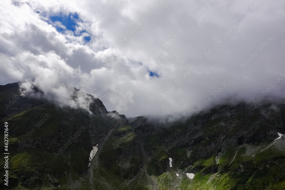 fog and clouds on the top of the mountains in the summer